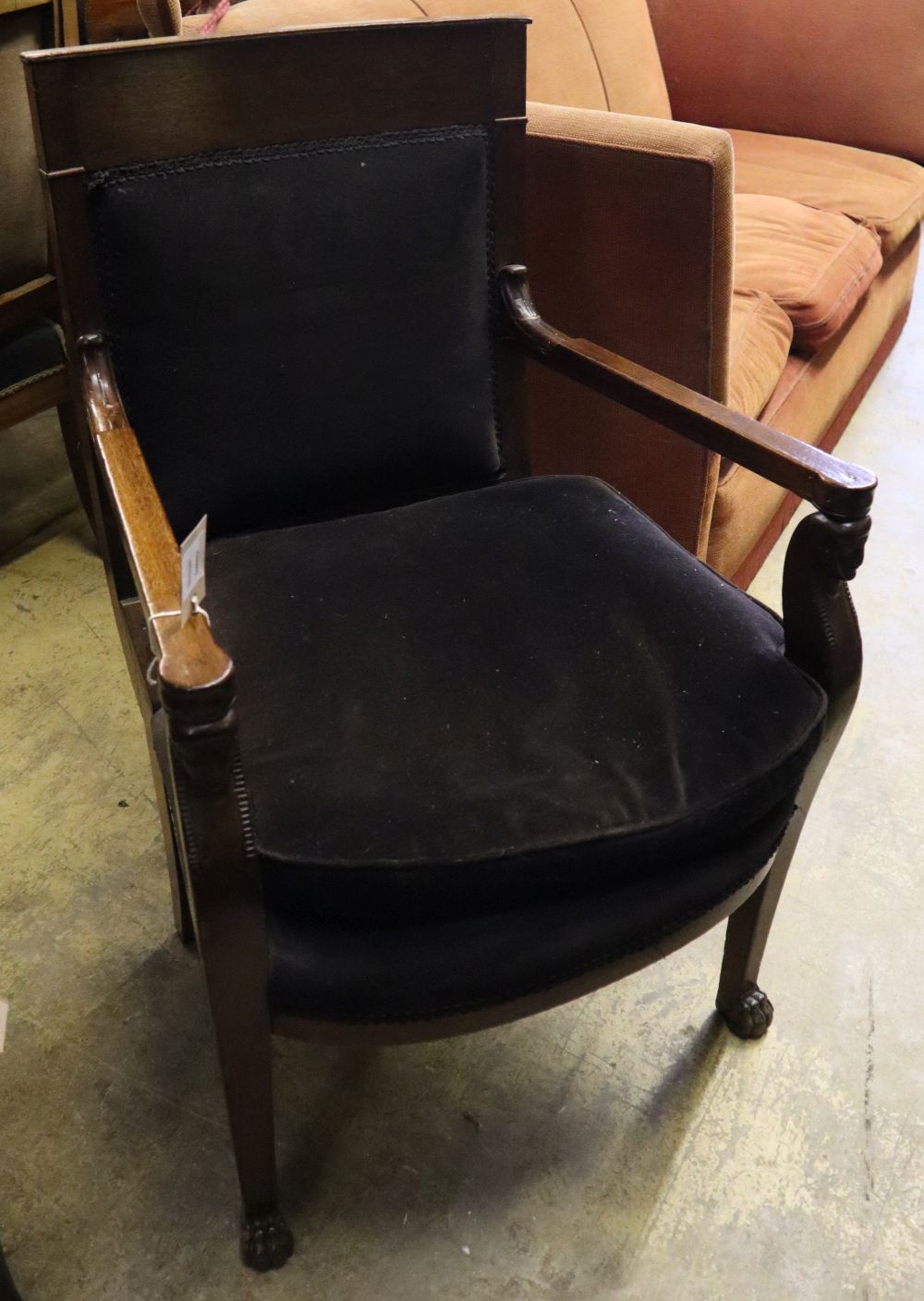 A French Empire mahogany fauteuil with lions paw feet